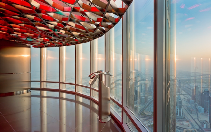 Burj Khalifa observation deck view of Dubai skyline at sunset.