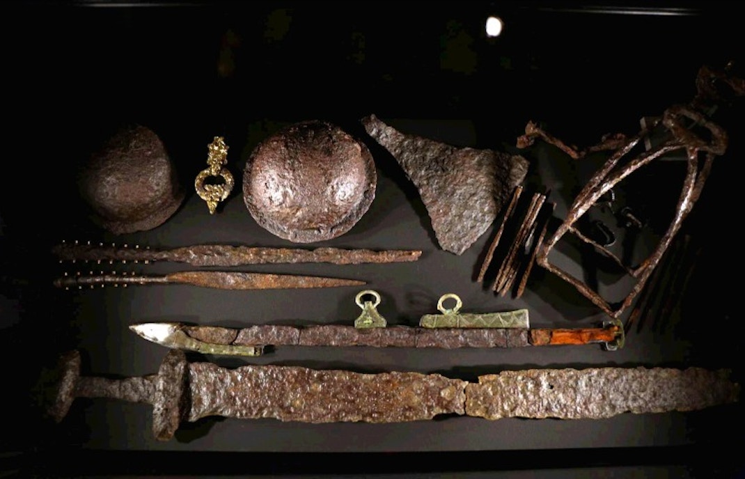 Viking artifacts including swords, helmets, and tools displayed at The Vikings Exhibition.