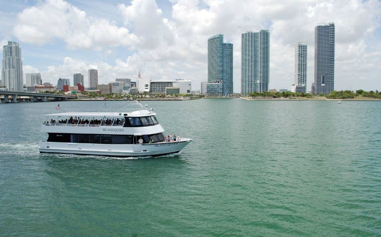Boat cruising Biscayne Bay with Miami skyline in the background.