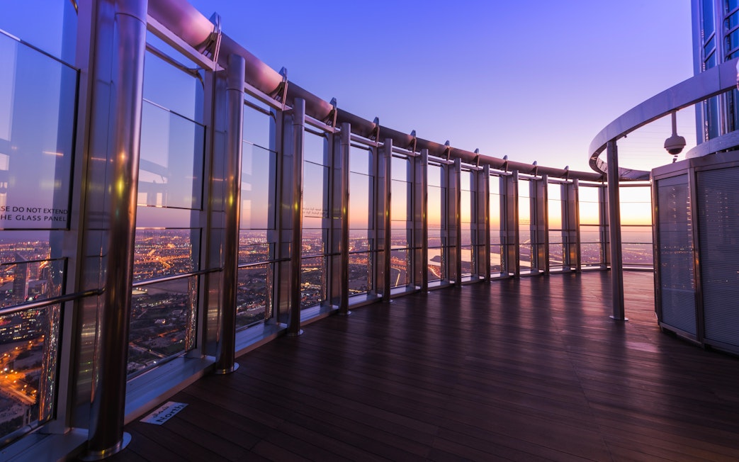 Burj Khalifa observation deck view at sunset, Dubai skyline in the background.
