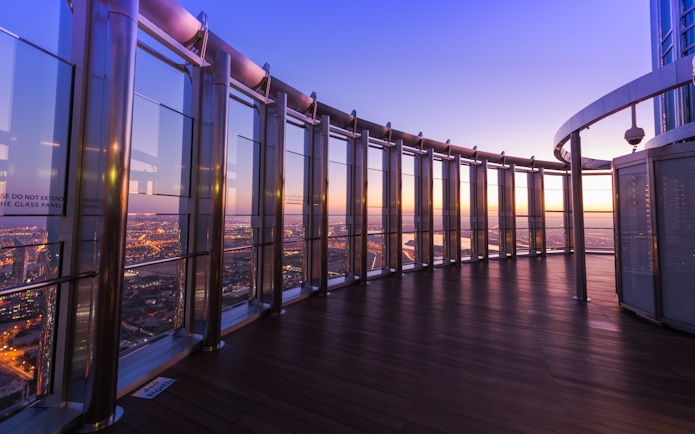 Burj Khalifa observation deck view at sunset, Dubai skyline in the background.