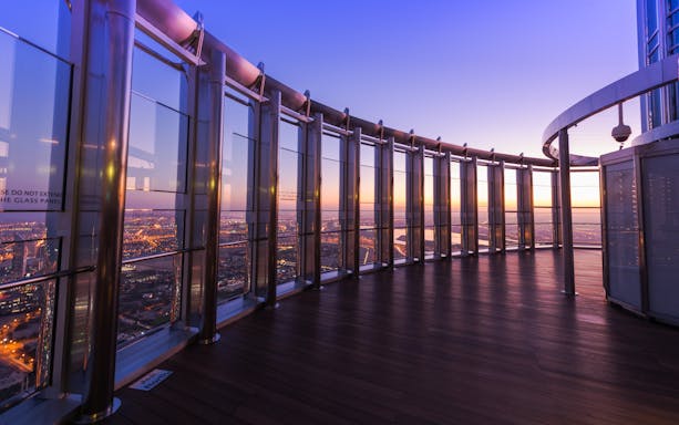 Burj Khalifa observation deck view at sunset, Dubai skyline in the background.