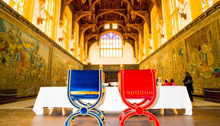 Two ornate chairs in the Great Hall of Hampton Court Palace, England.