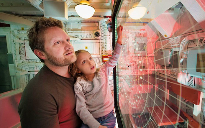 Father and daughter exploring radar room on HMS Belfast.