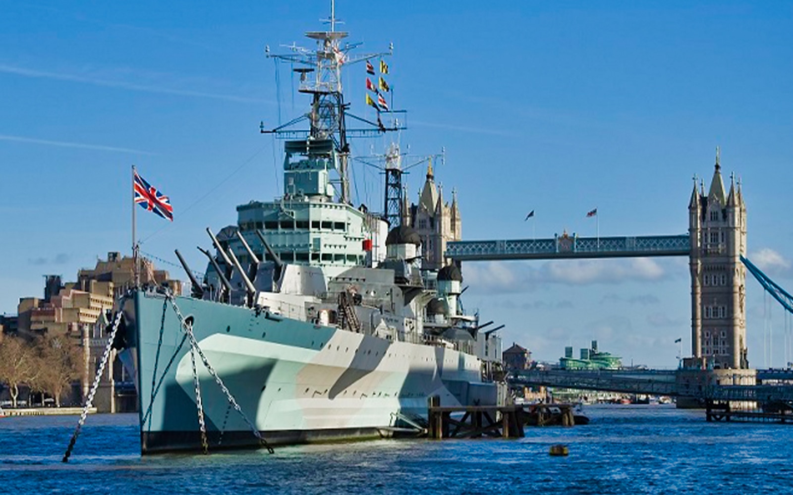 HMS Belfast moored on the River Thames with Tower Bridge in the background, London.