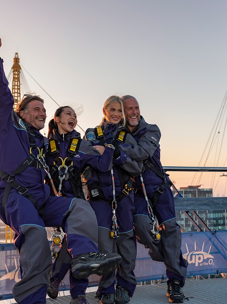 People celebrating on the O2 Arena roof at sunset during Up At The O2 adventure in London.