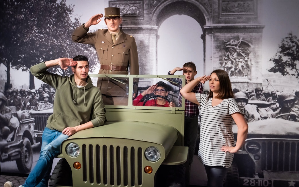 Visitors posing with a wax figure of a military officer at Grévin Paris Wax Museum.