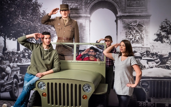 Visitors posing with a wax figure of a military officer at Grévin Paris Wax Museum.