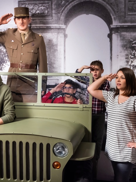 Visitors posing with a wax figure of a military officer at Grévin Paris Wax Museum.