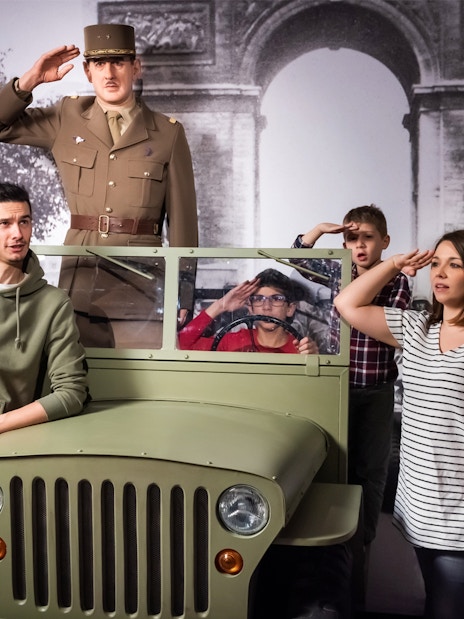 Visitors posing with a wax figure of a military officer at Grévin Paris Wax Museum.