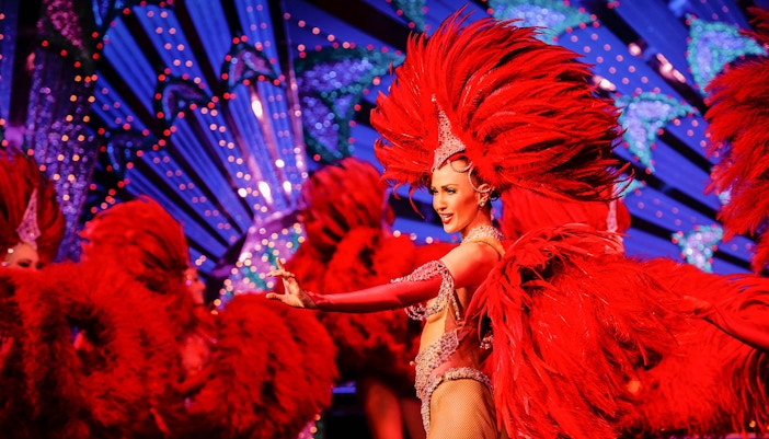 Moulin Rouge cabaret dancers performing on stage during dinner in Paris, France.