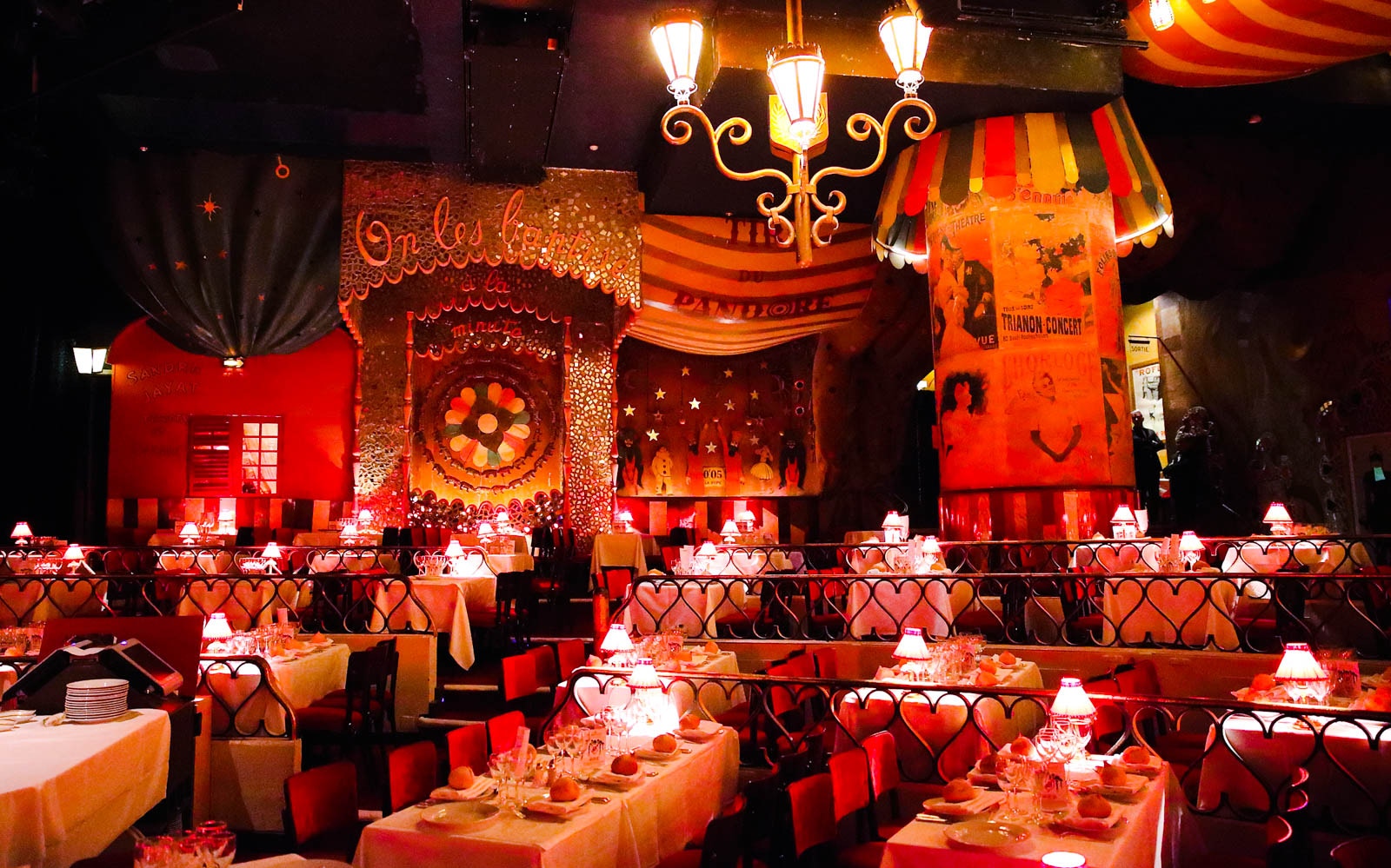 Moulin Rouge Paris exterior illuminated at night with vibrant lights and iconic windmill.