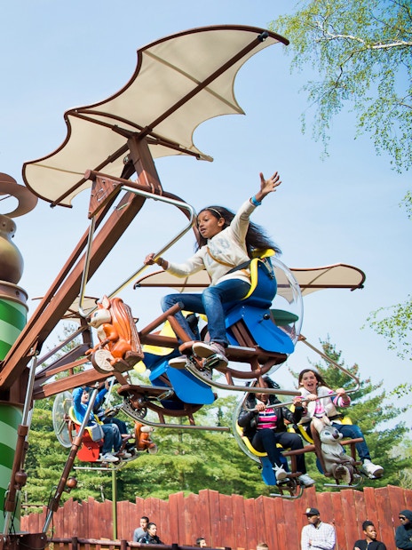 Visitors enjoying a flying carousel ride at Astérix Park, Paris, France.
