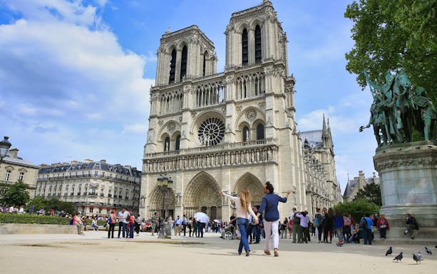 Notre-Dame Cathedral in Paris with tourists exploring the plaza.