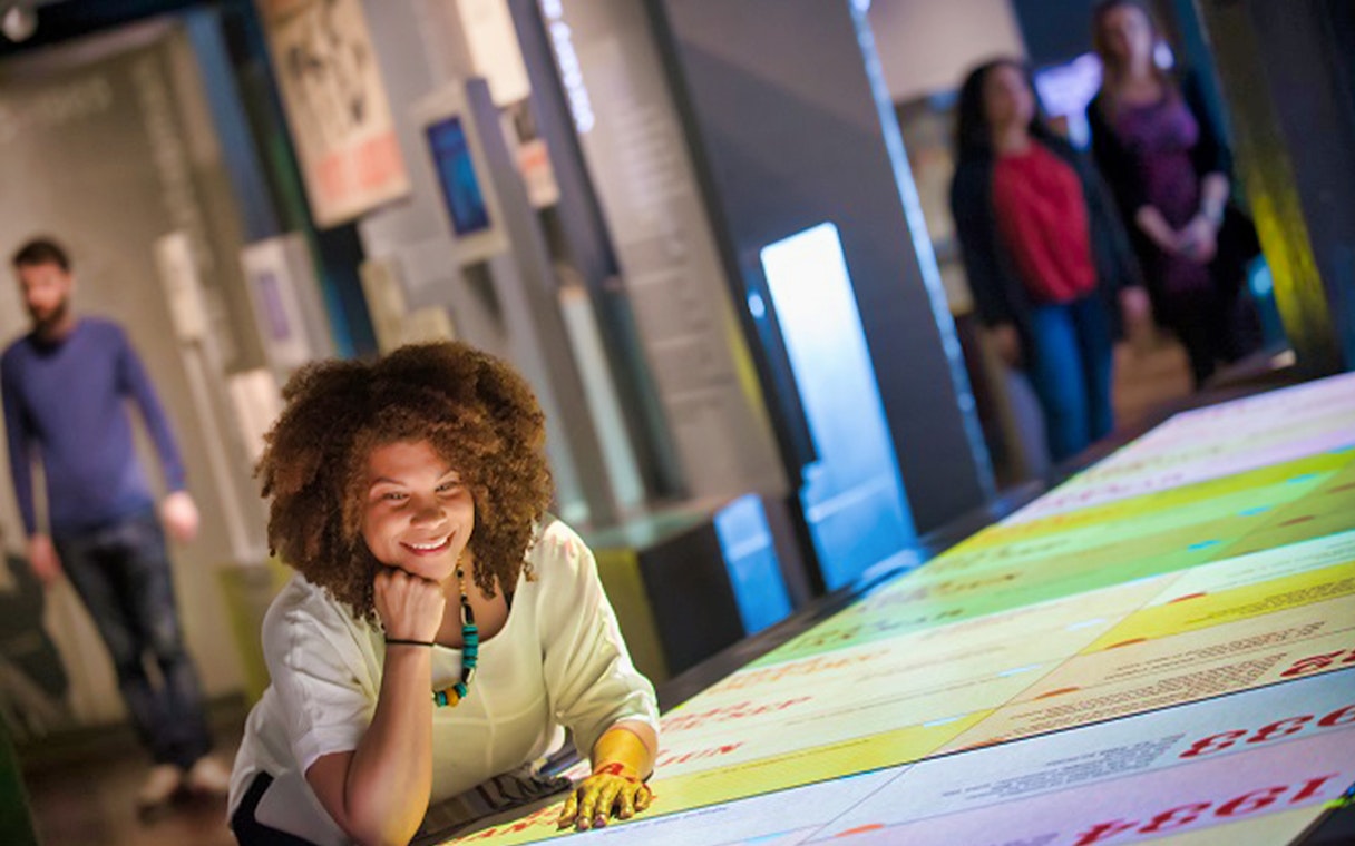 Visitor exploring interactive exhibit at Churchill War Rooms, London.