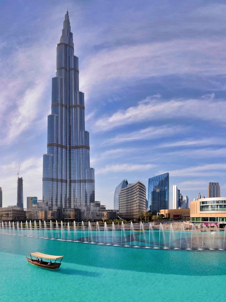 Burj Khalifa towering over Dubai Fountain with city skyline in the background.