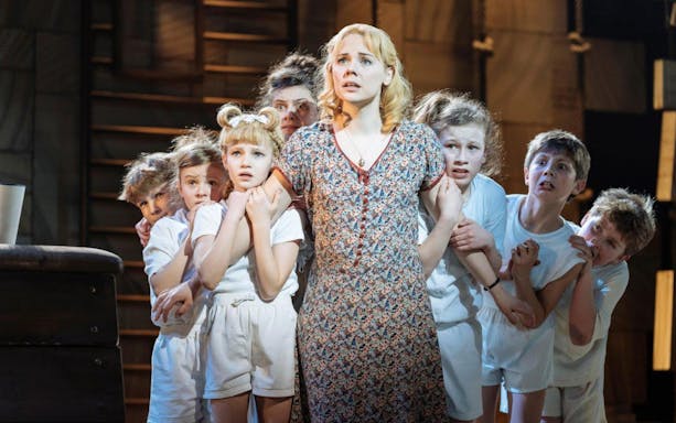Children and an adult on stage during a scene from Matilda The Musical.