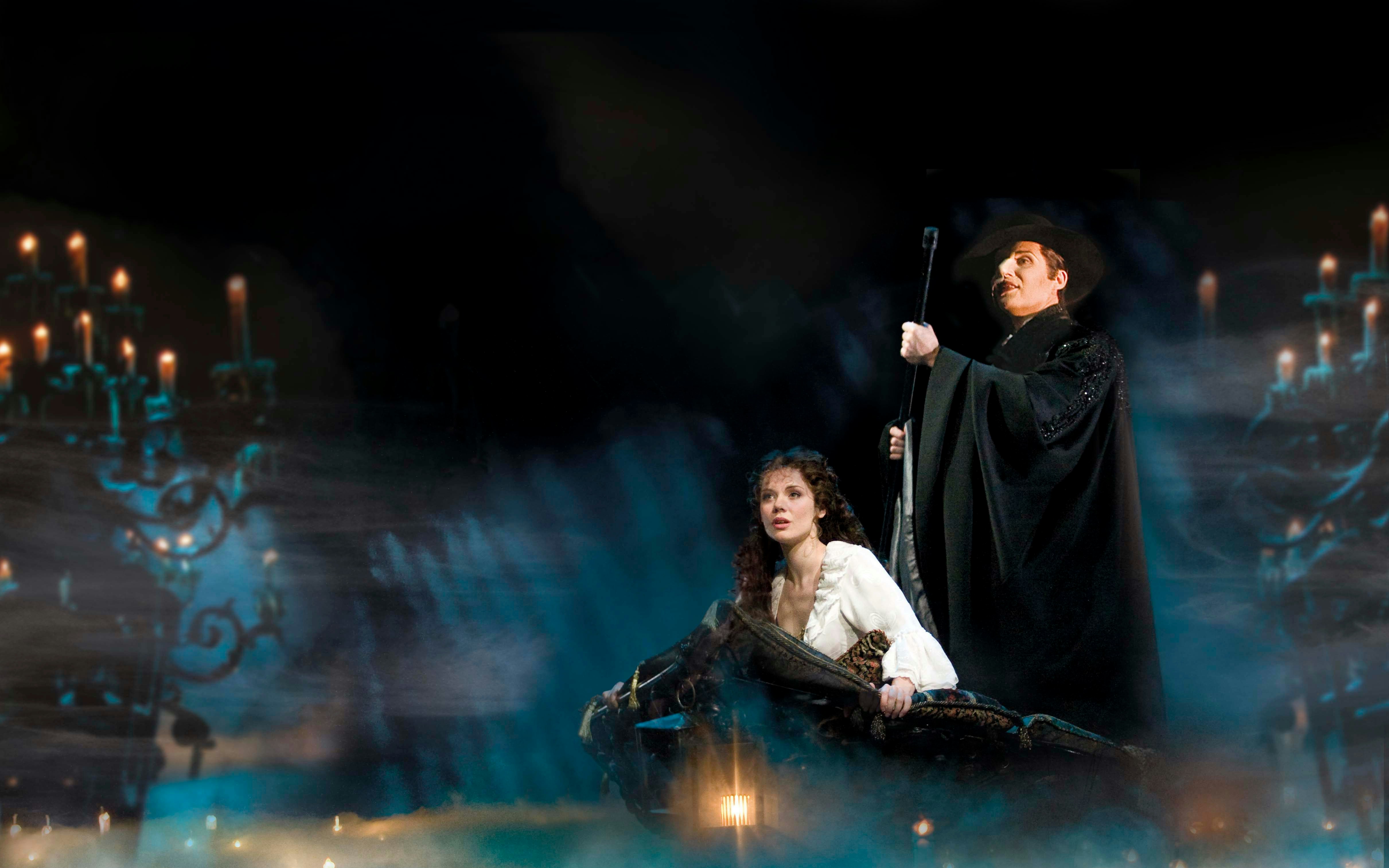 Phantom of the Opera scene with characters on a boat surrounded by candlelight.