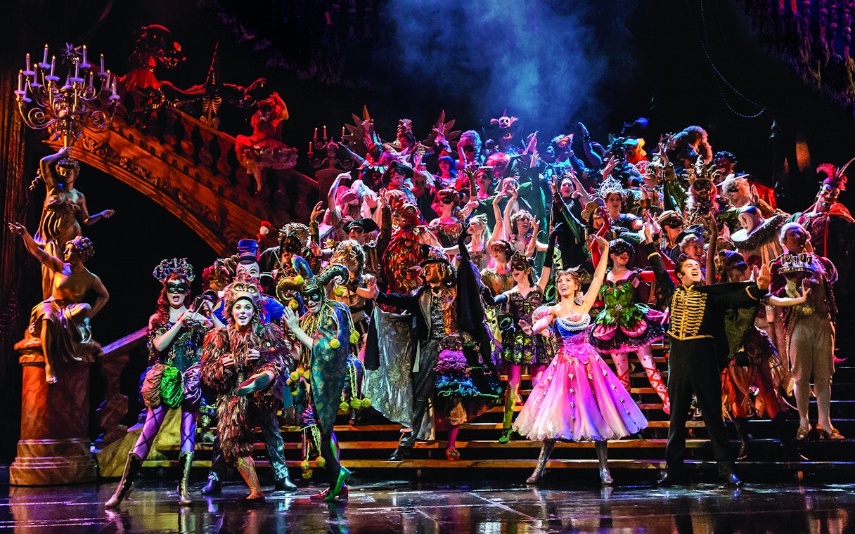 Cast performing a vibrant masquerade scene in Phantom of the Opera, West End.