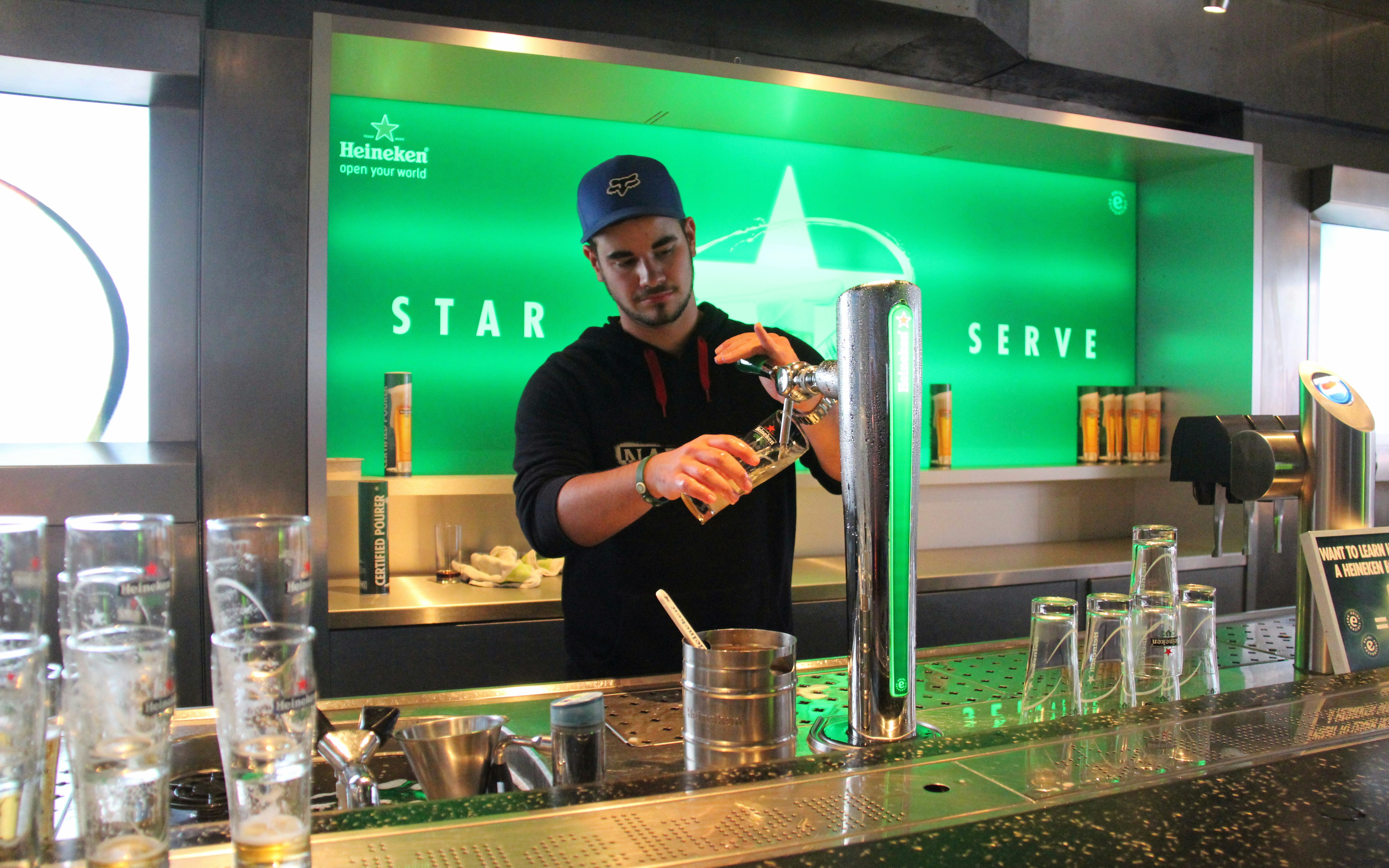 Heineken Experience entrance in Amsterdam with visitors entering the historic brewery.