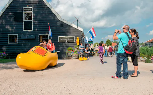 Visitors at Zaanse Schans with large wooden clog, part of Volendam, Edam, and Windmills Tour.