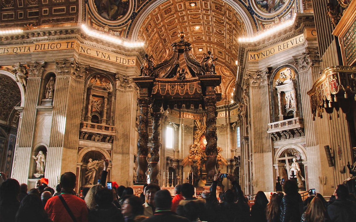 Interior of St. Peter's Basilica with tourists, featured on the Official Angels & Demons Tour.
