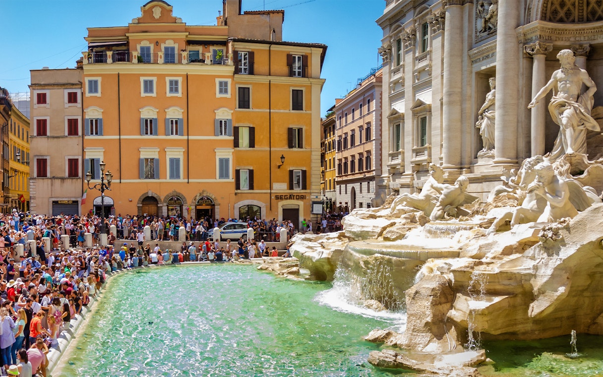 Trevi Fountain in Rome with a crowd of tourists, part of the Official Angels & Demons Tour.
