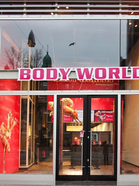 Body Worlds Amsterdam entrance with anatomical displays inside.