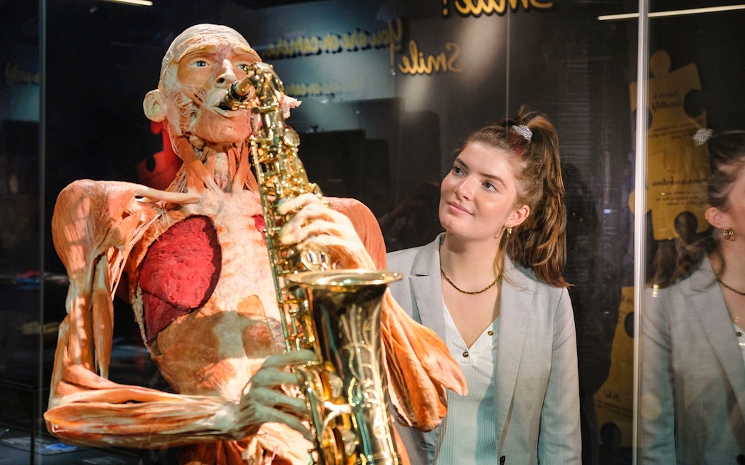Body Worlds Amsterdam exhibit featuring a human anatomy model playing a saxophone.