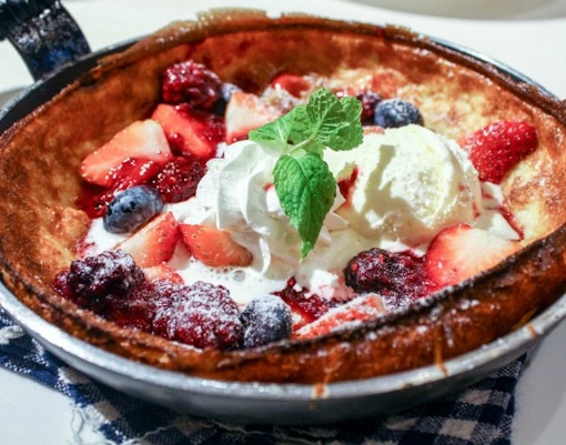 Home-cooked Dutch pancake with berries and cream on Amsterdam food tour.