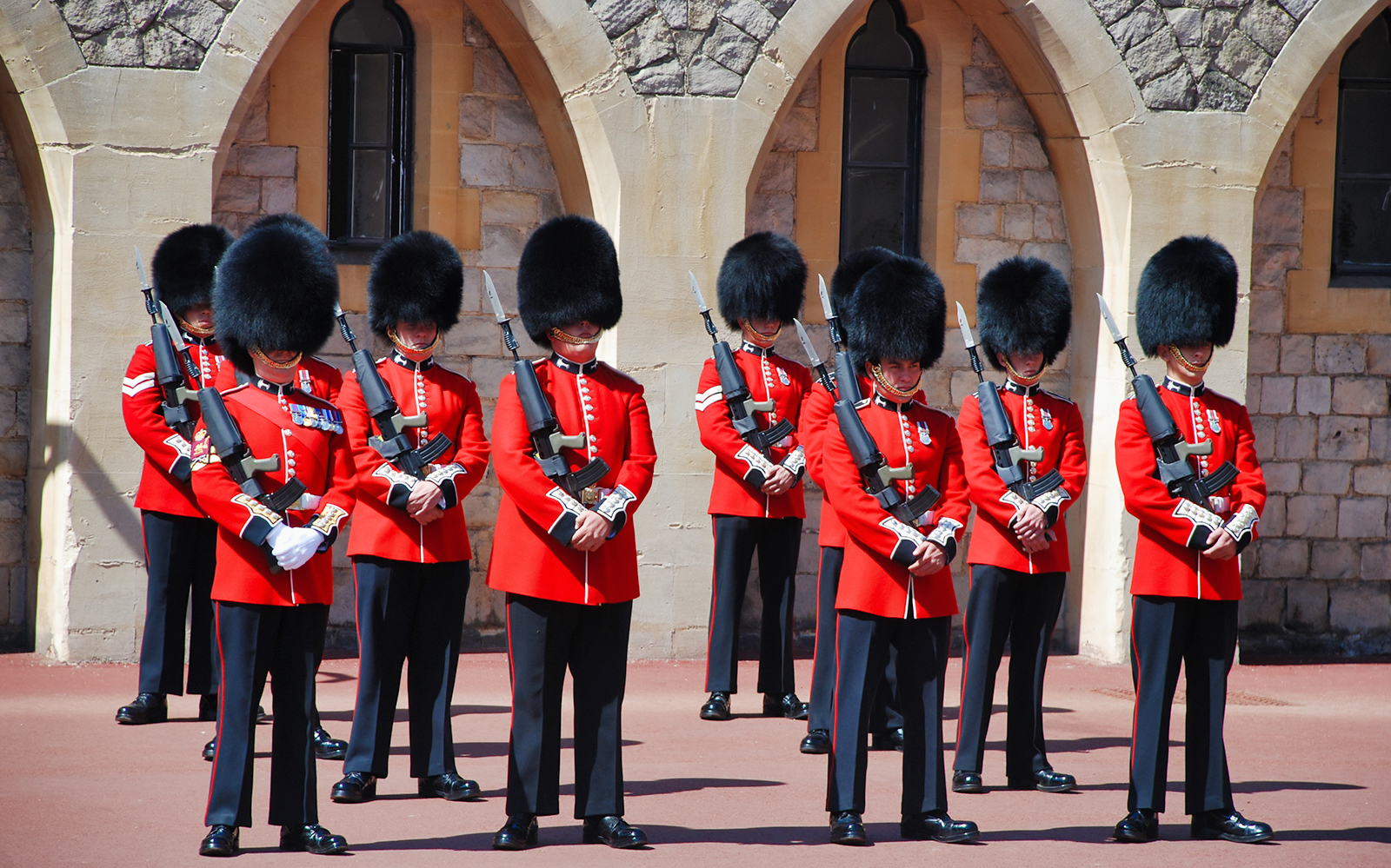 Guards in red uniforms and bearskin hats at Windsor Castle.