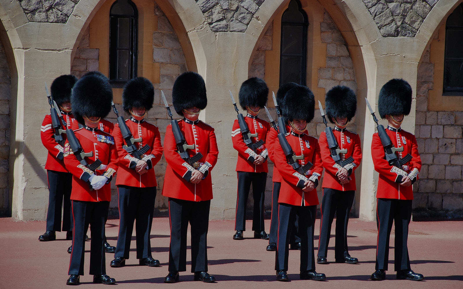 Guards in red uniforms and bearskin hats at Windsor Castle.