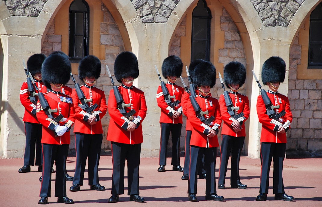 Guards in red uniforms and bearskin hats at Windsor Castle.