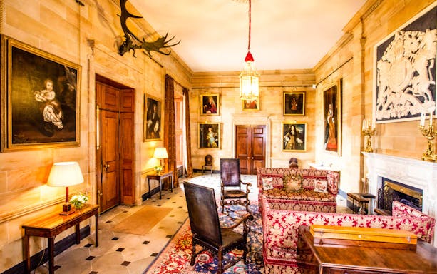 Hillsborough Castle interior with antique furniture and historic paintings on the walls.