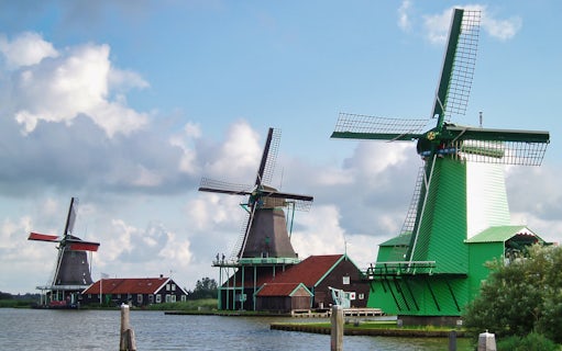Windmills by the water in Zaanse Schans, Netherlands, part of the Amsterdam: Windmills, Edam and Volendam Tour.