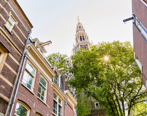 Clock tower and historic buildings on an Amsterdam walking tour.