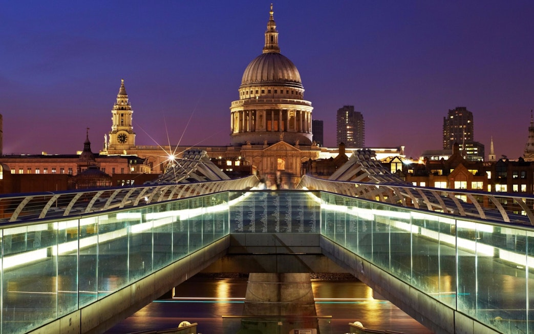 Millennium Bridge leading to St Paul's Cathedral in London at dusk.