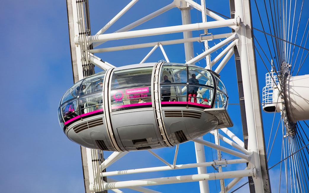 London Eye capsule with passengers against a blue sky.