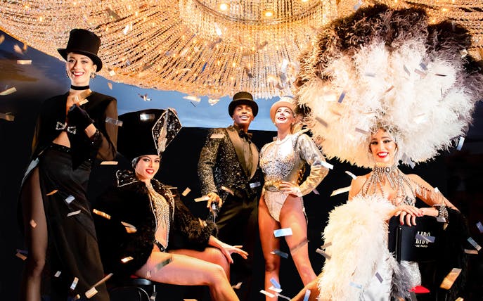 Performers in elegant costumes at The Lido Show with Champagne, Paris.
