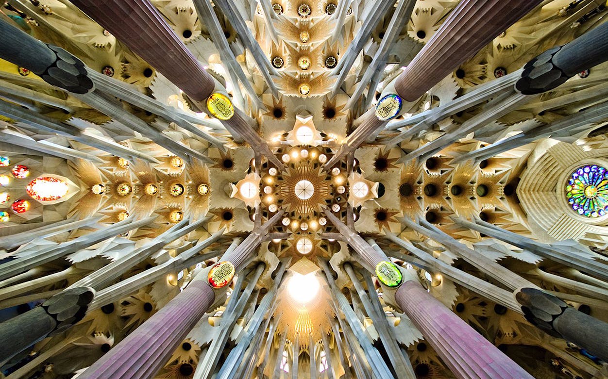 Interior ceiling view of Sagrada Familia basilica in Barcelona, showcasing intricate architectural details.