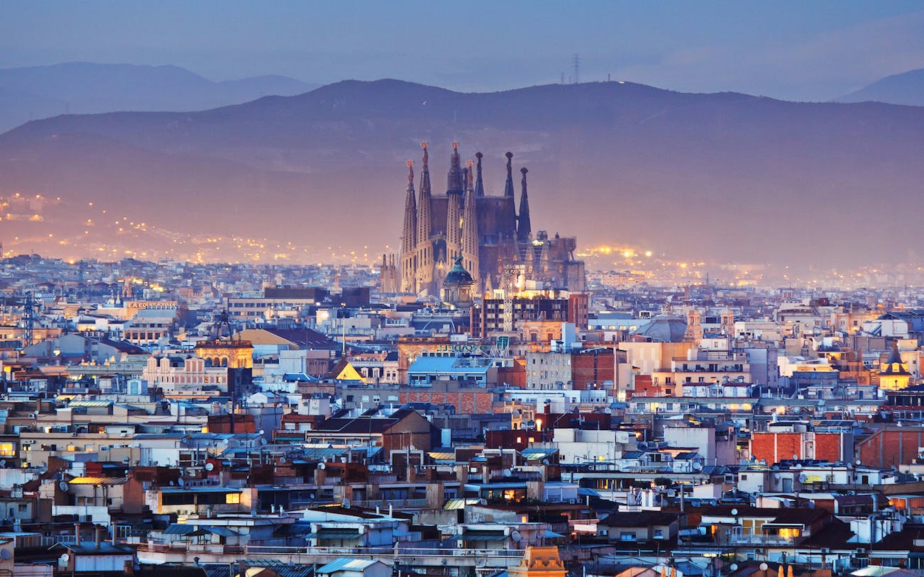 Sagrada Familia view over Barcelona cityscape at dusk.