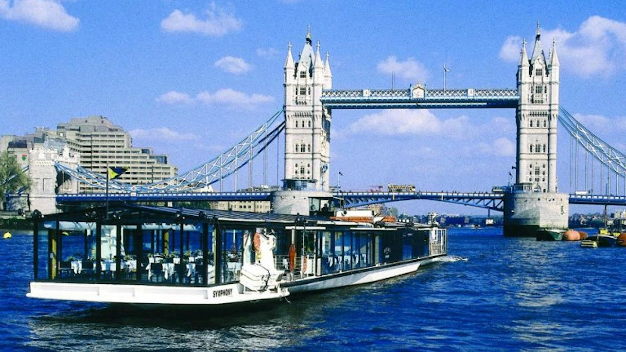 River cruise boat passing under Tower Bridge in London.