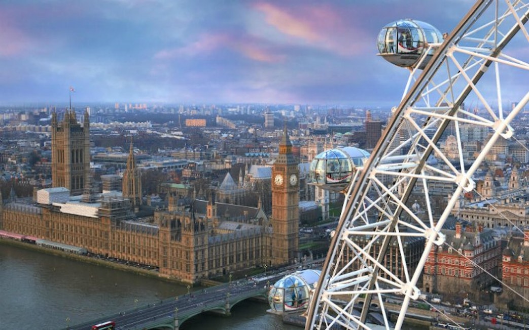 London Eye overlooking Big Ben and Houses of Parliament at sunset.