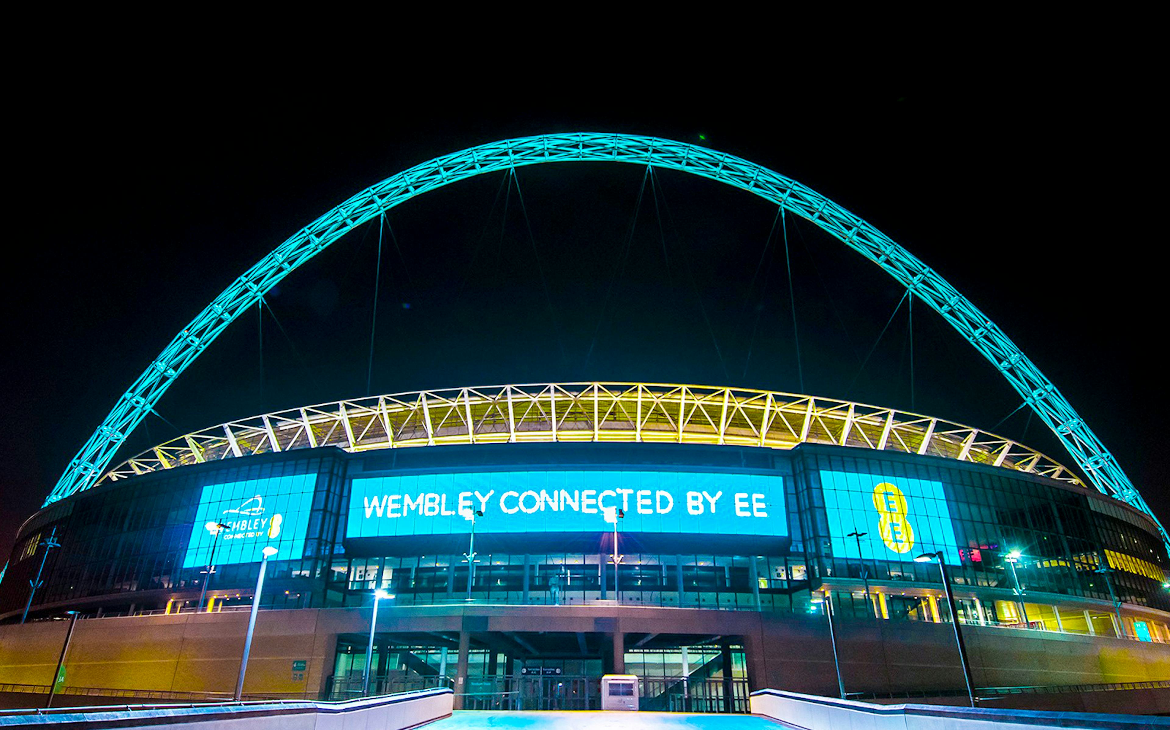 Wembley Stadium illuminated at night, showcasing the iconic arch in London.