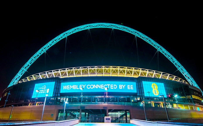 Wembley Stadium illuminated at night, showcasing the iconic arch in London.