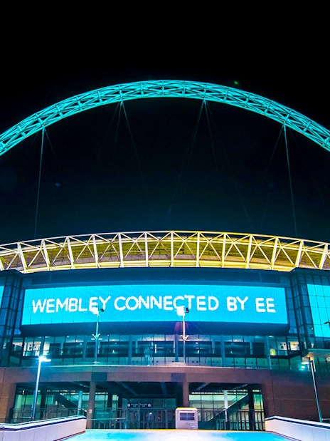 Wembley Stadium illuminated at night, showcasing the iconic arch in London.