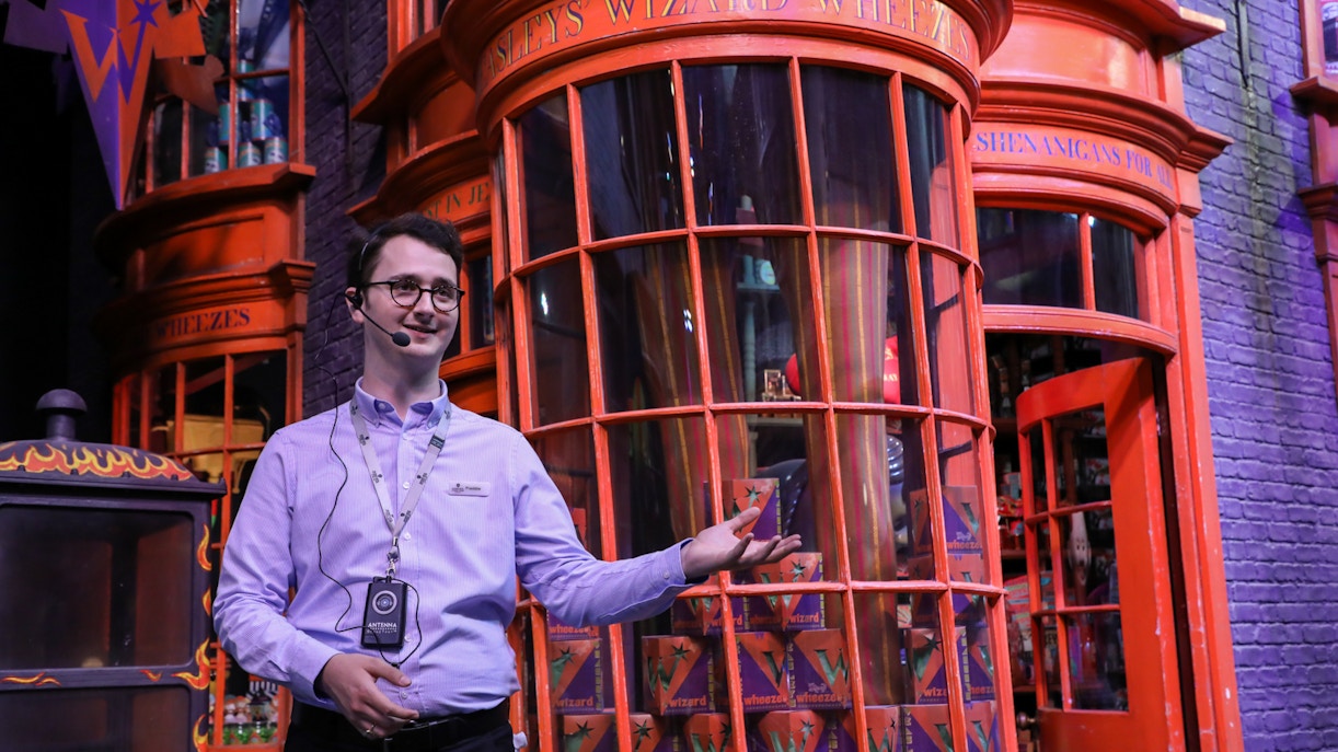 Tour guide leading visitors through Warner Bros. Studio Harry Potter Tour, London.