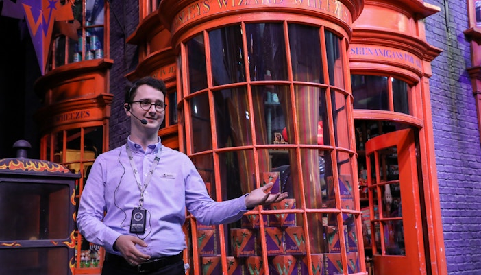 Tour guide leading visitors through Warner Bros. Studio Harry Potter Tour, London.