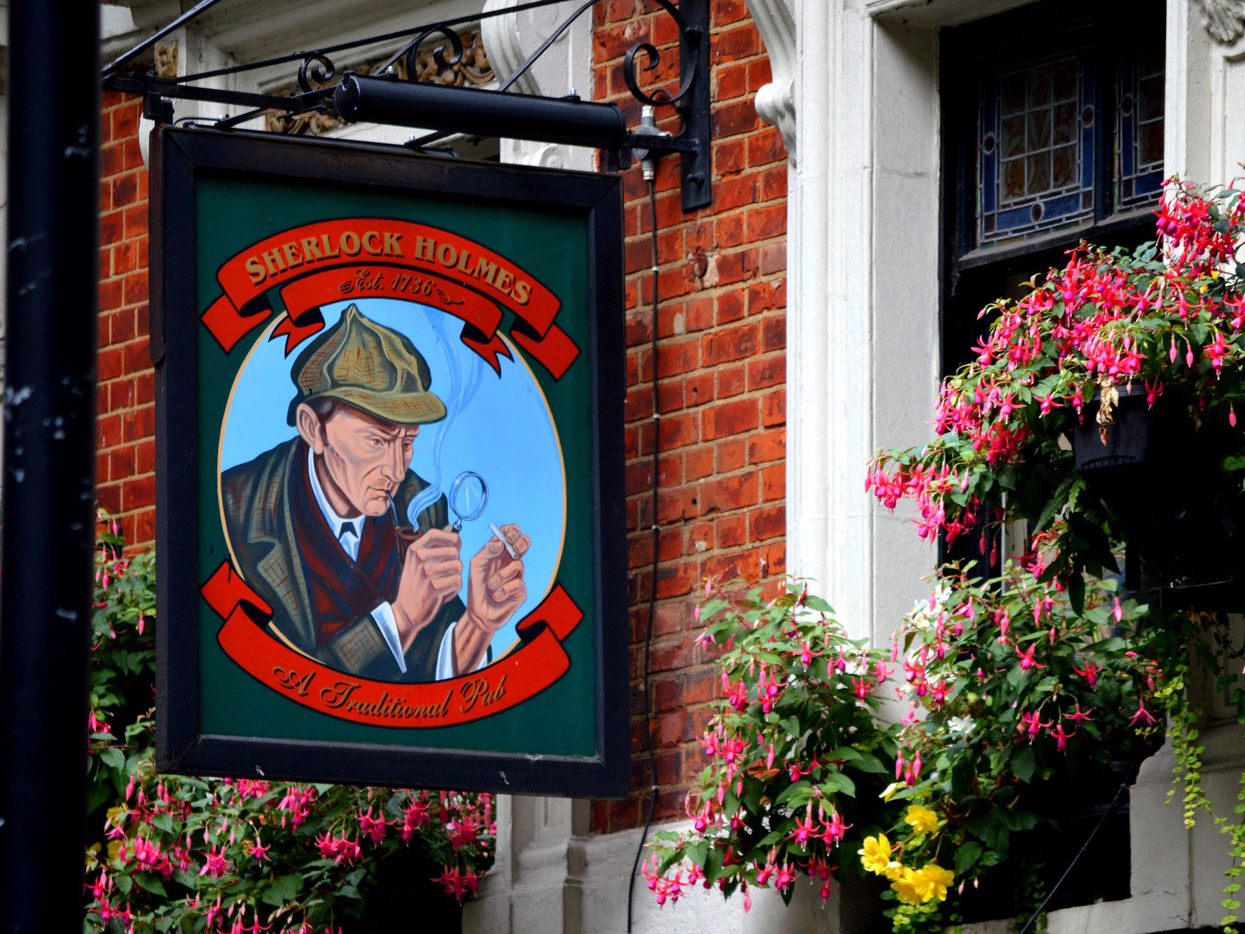 Sherlock Holmes pub sign with magnifying glass in London.
