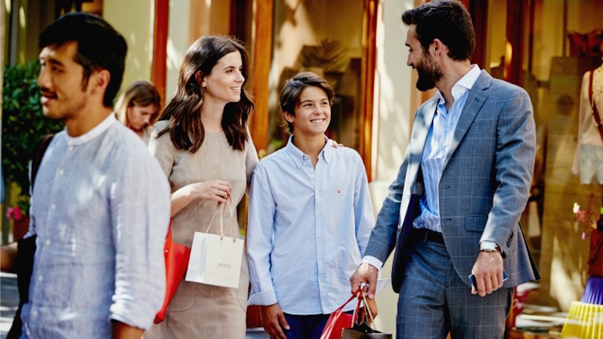 Shopping at Las Rozas Village with family carrying bags.